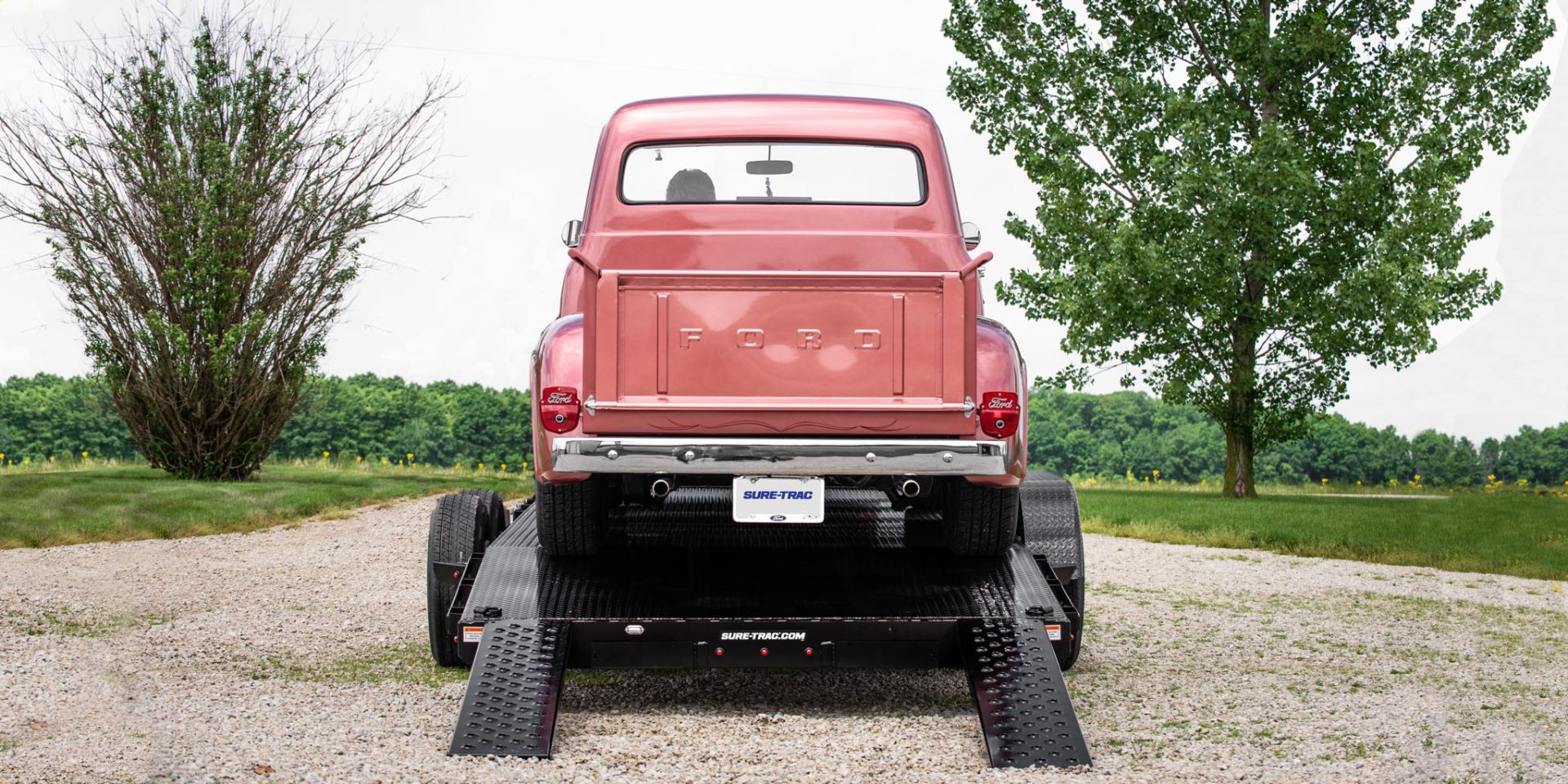 back view of a car hauler trailer with a car on it